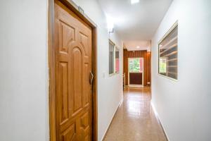 蒙纳FabHotel Abrigo Residency的房屋内带木门的走廊