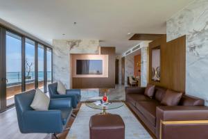 岘港KOI Resort & Residence Da Nang的客厅配有沙发、椅子和桌子