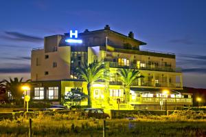 阿霍Hotel Costa de Ajo的一座棕榈树环绕的大建筑