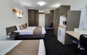 洛坎普顿阿彻公园汽车旅馆的小型酒店客房设有两张床和厨房。