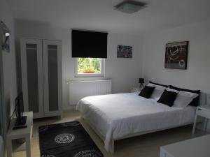 谢林伯尔维拉贝尔阿米公寓的卧室配有白色的床和电视。