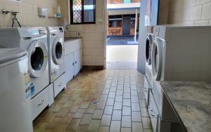 洛坎普顿阿彻公园汽车旅馆的一间洗衣房,配有洗衣机和瓷砖地板