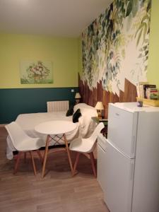 圣萨蒂南艾普特chez lulu的厨房配有桌椅和冰箱。