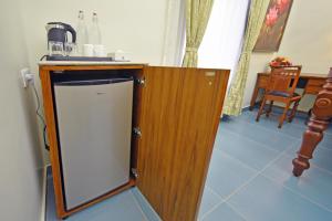 蓬蒂切里Le Colonial Suites的厨房配有带水槽的柜台和冰箱。
