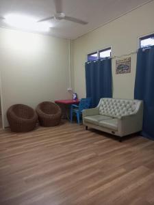瓜拉丁加奴Bilik Bajet RM70-RM90的带沙发、桌子和蓝色窗帘的客厅