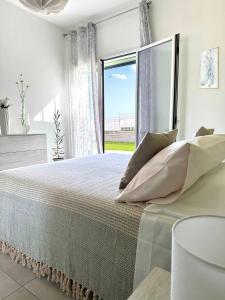 奥古斯塔Villa Flora, Piscina Esclusiva e Mare的一间卧室设有一张大床和大窗户