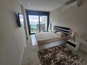 阿拉尼亚Konak Tower Seaside mahmutlar的一间卧室设有一张床和一个大窗户