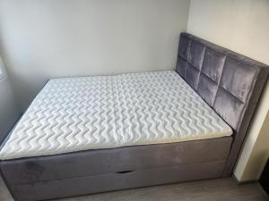 拉赫蒂Uusi huvila Lahdessa的一张位于带灰色床垫的房间里的床