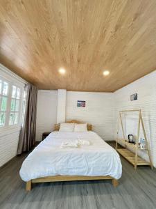 大叻Scent Village Hotel的一间卧室设有一张带木制天花板的大床