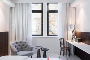 斯图加特Ruby Hanna Hotel Stuttgart的一间卧室配有一张床、一把椅子和窗户。