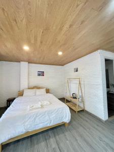 大叻Scent Village Hotel的一间卧室设有一张带木制天花板的大床
