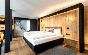 安德马特Hotel Piz Badus的一间卧室设有一张带木墙的大床