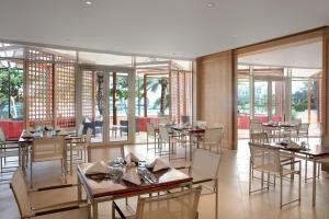 穆萨纳Barceló Mussanah Resort, Sultanate of Oman的餐厅设有桌椅和窗户。