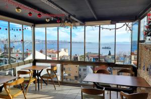 伊斯坦布尔马尔马拉宾馆的一间带桌椅并享有水景的餐厅