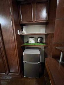 马尼拉Millennium Plaza Hotel的厨房内设有一个带小冰箱的小厨房
