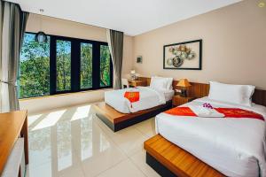 Takua ThungBangnu Greenery Resort的酒店客房设有两张床和窗户。