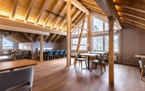 安德马特Hotel Piz Badus的餐厅设有木制天花板和桌椅