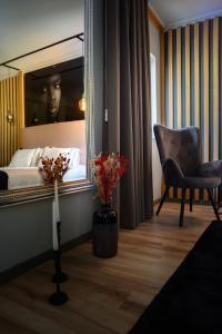 马塞杜-迪卡瓦莱鲁什Boutique Wine Hotel Panorama的一间设有镜子、椅子和床的房间