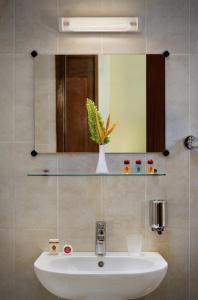 比绍Dunia Hôtel Bissau的浴室设有白色水槽和镜子