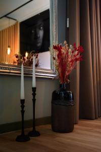 马塞杜-迪卡瓦莱鲁什Boutique Wine Hotel Panorama的黑色花瓶,上面有两根白色蜡烛和一张照片