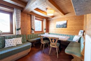 卡迪皮特拉Panorama-Apartments Oberkofl的小木屋内的用餐室,配有桌椅