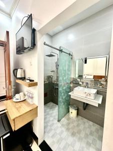Bạc LiêuPhụng Hoàng Vũ的一间带玻璃淋浴和水槽的浴室