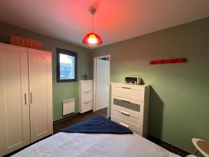 米雷Le Studio de Vasconia的一间卧室配有一张床和红灯