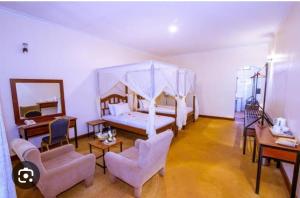 卡拉图MACHAGE TOURS AND SAFARIS HOTEL的一间卧室配有一张带天蓬的床