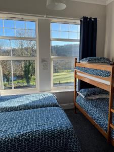 班戈Y Garth Guesthouse的一间卧室设有两张床和两个窗户。