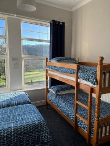 班戈Y Garth Guesthouse的一间卧室设有两张双层床和一扇窗户。