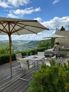 莱温Ferienwohnung "Auszeit Im alten Weinberg"的庭院配有遮阳伞和桌椅。