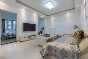 淮南淮南东城国际两居室公寓的一间卧室配有一张床和一台平面电视