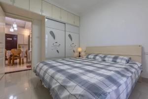 淮南淮南东城国际两居室公寓的一间卧室配有一张带蓝色和白色棉被的床