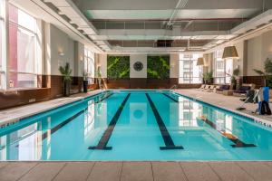 纽约Midtown West 2br w gym roofdeck nr Hudson NYC-1395的大楼内的一个蓝色海水游泳池