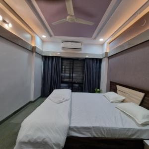 印多尔Leela Homestay Indore - Tulip - 2 BHK Luxury apartment的卧室设有一张白色大床和天花板