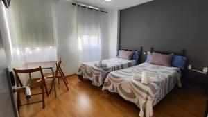 比亚雷亚尔Hello Villarreal Pension的一间卧室配有两张床和一张桌子及椅子