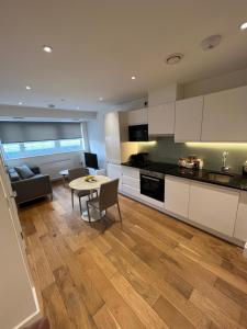 克罗伊登Trendy apartment in Croydon central的厨房以及带桌子和沙发的客厅。