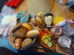 埃曼Jacuzzi huisje De Berenshoeve的一张桌子,上面放着一篮面包和一碗食物