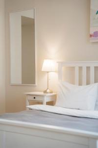 利沃夫达尼罗宾馆的卧室配有白色床、灯和镜子