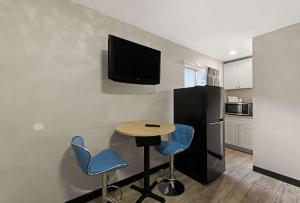 夏洛特Rodeway Inn的厨房配有一张桌子和两把椅子,墙上配有电视。