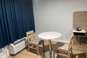 波莫纳Travelodge by Wyndham Fairplex Pomona的配有桌子、两把椅子和一张书桌的房间
