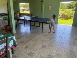 莫雷蒂斯Pousada do colono的一个小女孩在房间里打乒乓球