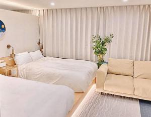 东京上野超豪华4人间 东京超级中心Ybod 上野公园3分钟 车站1分钟 超级繁华 免费wifi 戴森吹风的酒店客房,设有两张床和一张沙发