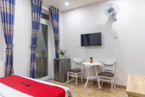 胡志明市Rita Hotel Home- Airport Tân Sơn Nhất- Cạnh Bệnh Viện Tâm Anh & Gần Quân Khu 7的客房设有1张床、1张桌子和1台电视。