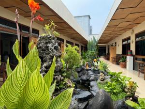 井里汶Hotel Priangan的一座花园,位于一座建筑的中间