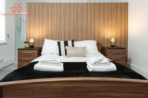 利物浦Spacious 5-Bedroom Oasis with Games Room-Liverpool的一间卧室配有一张大床和毛巾