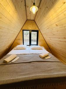 GlolaHilltop Glola的木制客房的一张床位,设有窗户