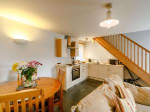 马根波思1 Bed in Newquay 89942的厨房以及带桌子和沙发的用餐室。