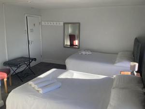 萨顿布里奇滨江酒店的两张位于酒店客房的床,配有毛巾