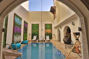 非斯Darif's Riad Fes & Spa的一座带拱门的房子中的室内游泳池
